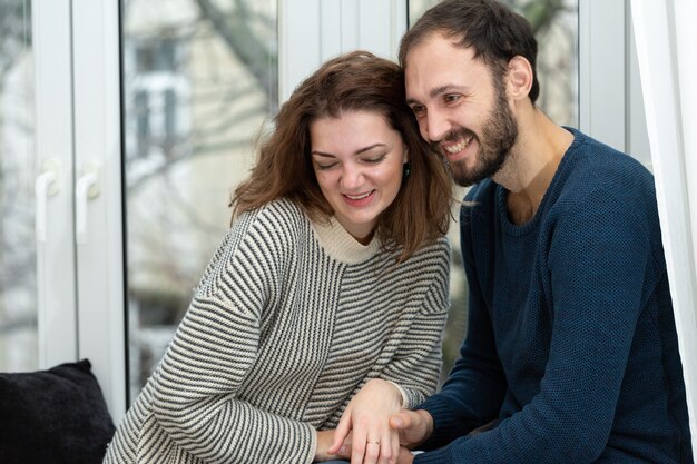 Pareja romántica mirando por la ventana. Cuarentena en casa.