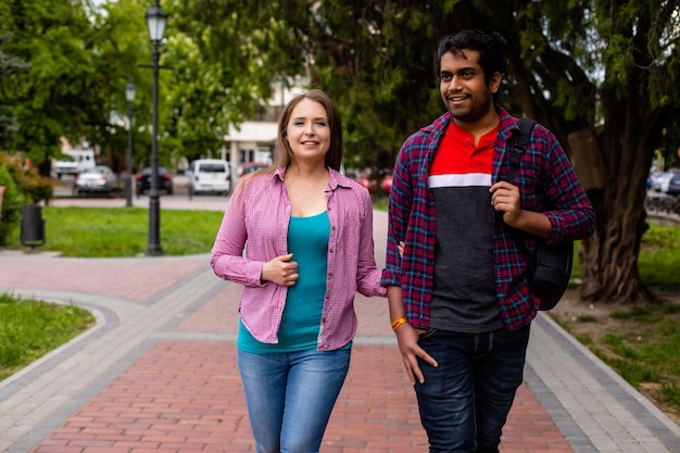 Pareja romántica multirracial caminando en un hermoso parque