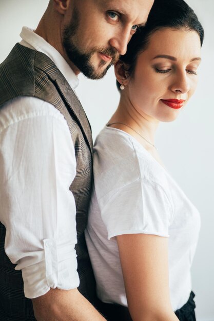 Pareja romántica Retrato familiar Disfrutando del amor Momentos seguros Un hombre guapo con barba abrazando a una mujer amada aislada en la vista lateral blanca