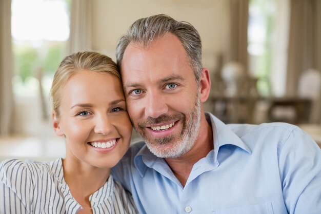 Pareja romántica sonriendo en la sala de estar