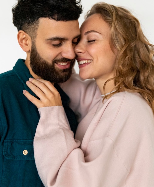 Foto pareja romántica sonriente besándose en casa