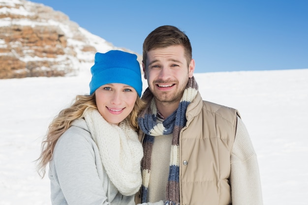 Pareja en ropa de abrigo en el paisaje cubierto de nieve