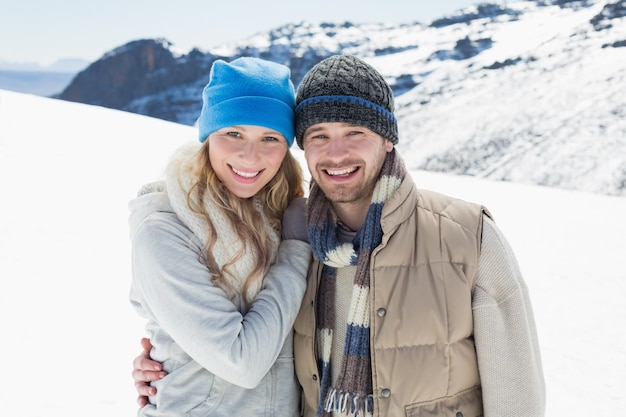 Pareja en ropa de abrigo en el paisaje cubierto de nieve