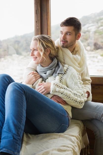 Pareja en ropa de invierno mirando a través de la ventana de la cabina