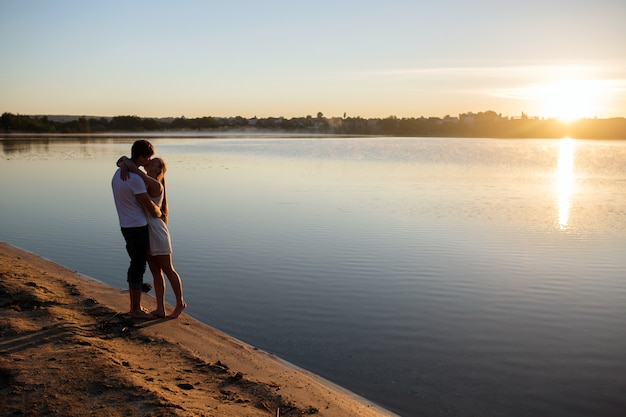 Pareja, en, salida del sol, en la playa