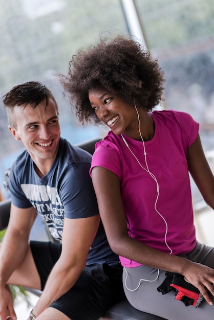 Foto pareja saludable tiene descanso en el gimnasio crossfit mujer afroamericana con peinado afro