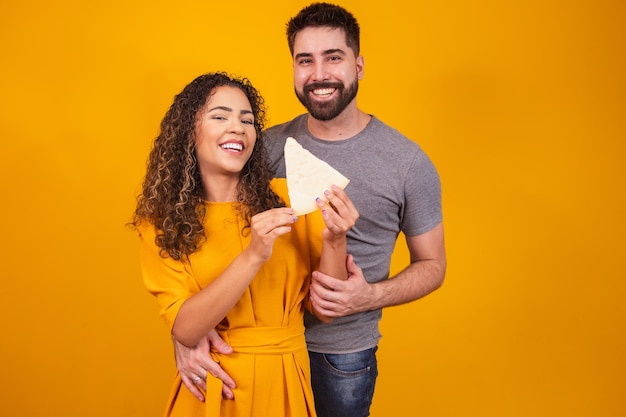 Pareja de san valentín comiendo queso sobre fondo amarillo