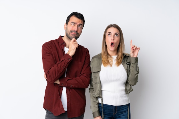 Foto pareja en san valentín sobre pared aislada de pie y pensando en una idea