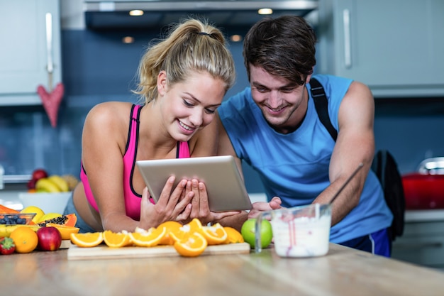 Pareja sana mirando tablet en la cocina