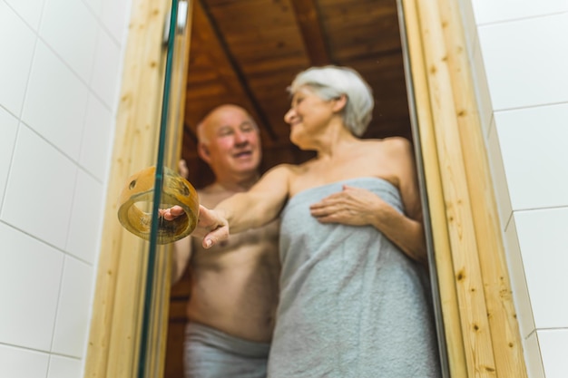 Una pareja en una sauna con un hombre y una mujer parados en la puerta.