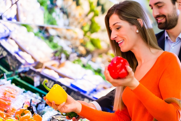 Pareja seleccionando verduras en hipermercado