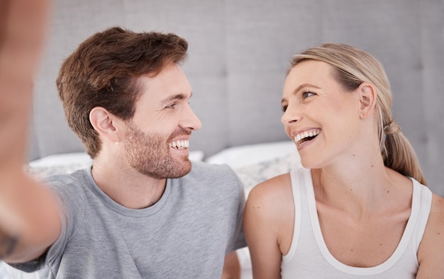 Pareja selfie amor feliz y relajarse en el dormitorio en casa sonrisa para el matrimonio y transmisión en vivo en las redes sociales juntos en casa Influyente hombre y mujer con foto para internet en línea en vacaciones