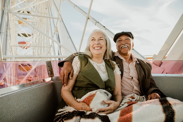 Pareja senior alegre disfrutando de una noria por el muelle de Santa Mónica