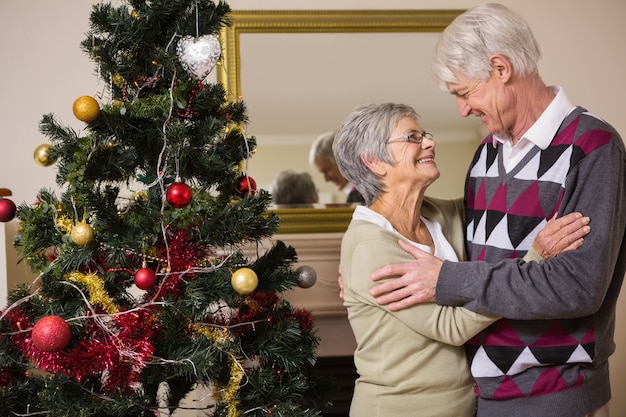 Pareja Senior decorando su árbol de Navidad