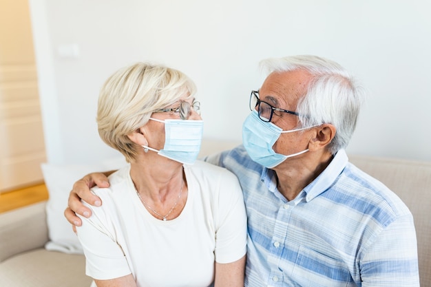 Pareja senior con máscara protectora en cuarentena en casa