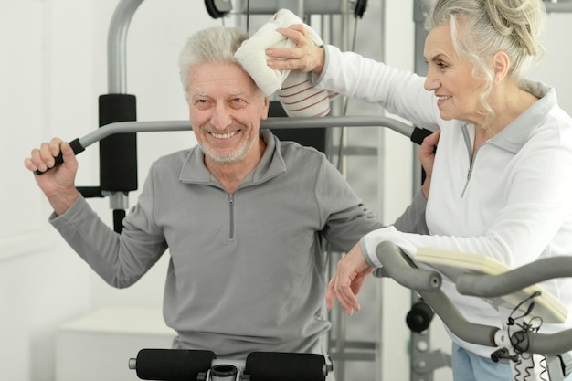 Pareja senior sonriente activa haciendo ejercicio juntos en el gimnasio