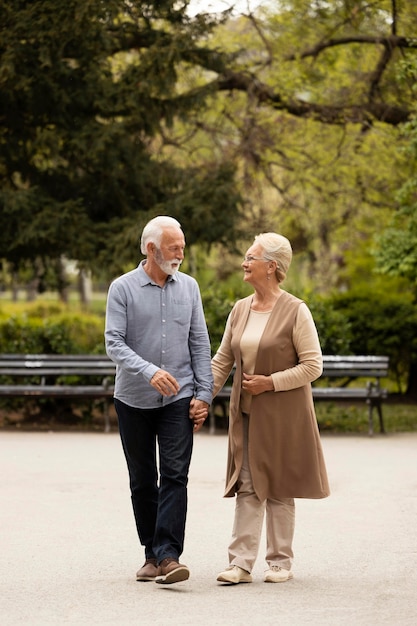 Pareja senior de tiro completo tomados de la mano