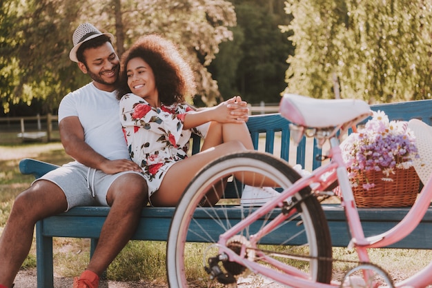 Pareja sentada en el banco en el parque de bicicletas fecha