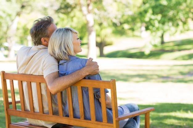 Pareja sentada en el banco del parque