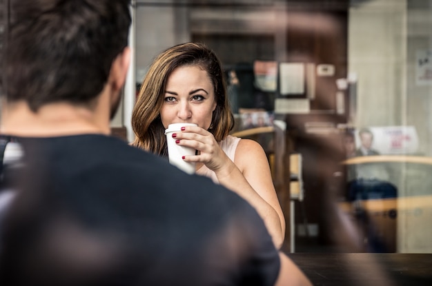 Pareja sentada en una cafetería tomando café