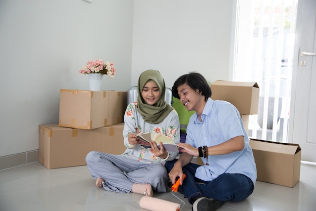 Pareja sentada en una casa nueva recogiendo color