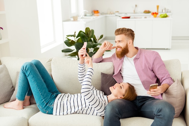 Pareja sentada en el sofá en casa y disfrutando de su tiempo