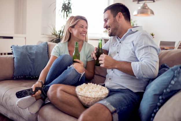 Pareja sentada en el sofá viendo la televisión