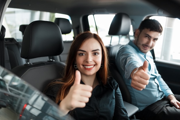 pareja sentada en su auto nuevo