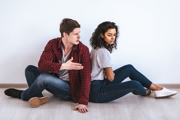 La pareja sentada en el suelo y peleando