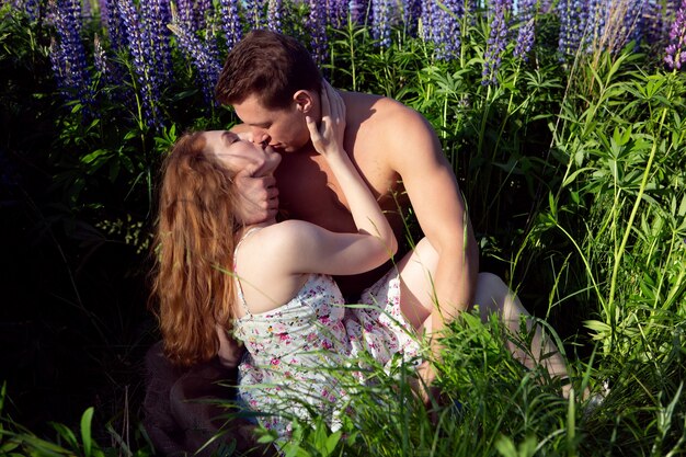 pareja sexy en un campo floreciente en un día soleado.