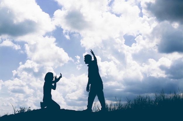 Foto una pareja de siluetas luchando en el campo contra el cielo nublado