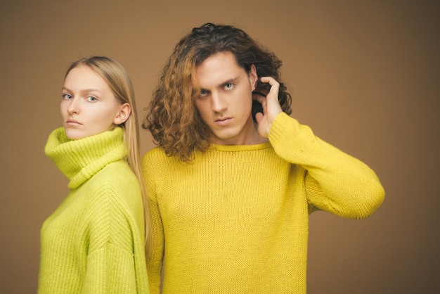 Pareja sobre fondo beige en estudio pareja de hombre con cabello rizado y mujer rubia en peluquería s