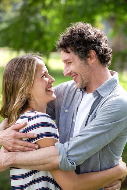 Pareja sonriente abrazando en el parque