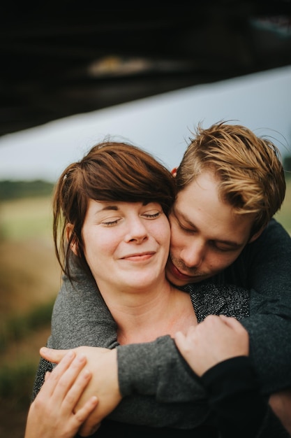 Una pareja sonriente abrazándose en el parque.