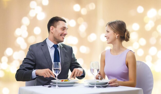 una pareja sonriente comiendo aperitivos en un restaurante