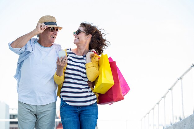 Pareja sonriente contra el cielo en la ciudad