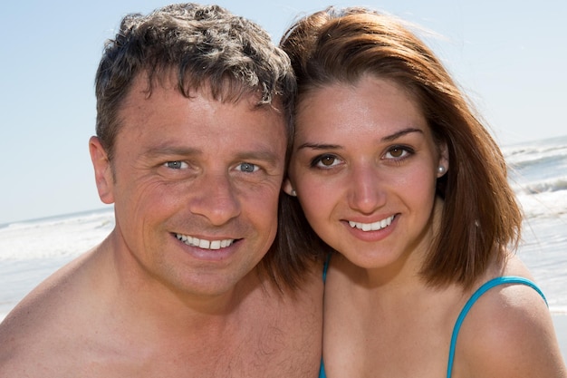 Pareja sonriente disfrutando en la playa en un día soleado