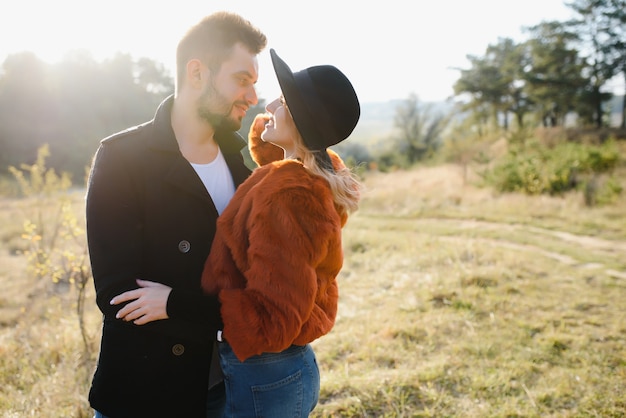 Pareja sonriente divirtiéndose en el parque otoño