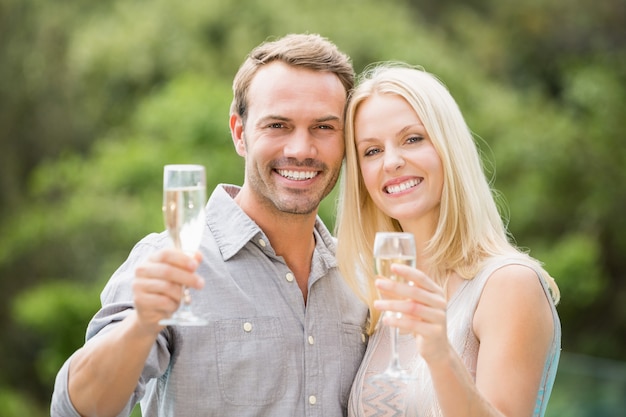 Pareja sonriente con flautas de champán