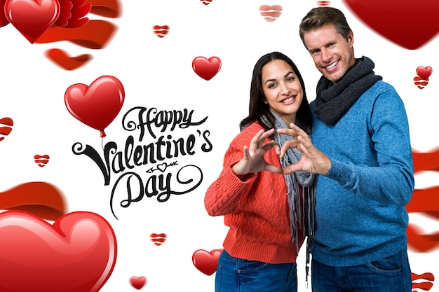 Foto pareja sonriente haciendo forma de corazón con las manos contra lindo mensaje de san valentín