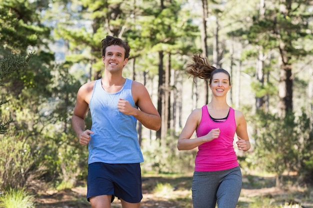 Pareja sonriente joven corriendo