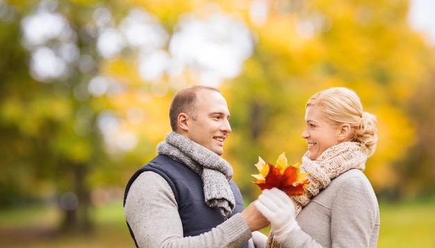 Foto una pareja sonriente en el parque de otoño.