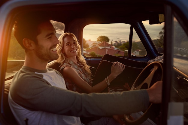 Una pareja sonriente sentada en el coche