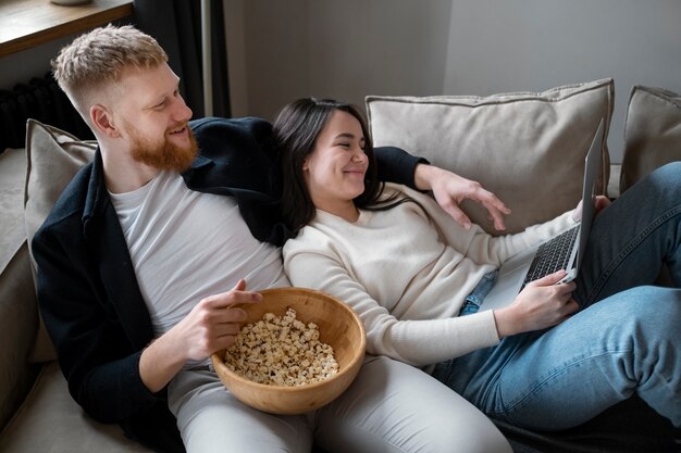 Pareja sonriente de tiro medio viendo una película