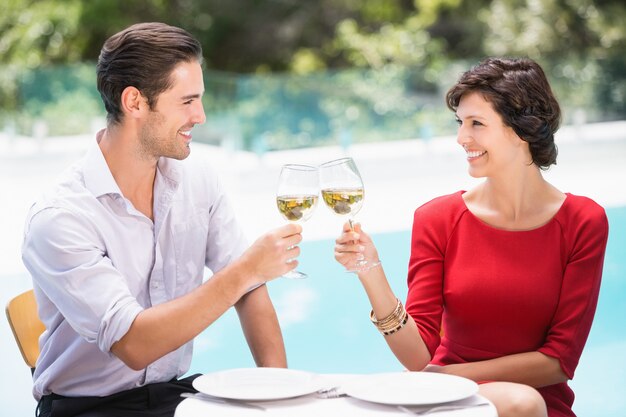 Pareja sonriente tostado vino blanco