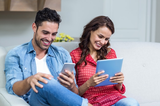 Foto pareja sonriente usando tecnología