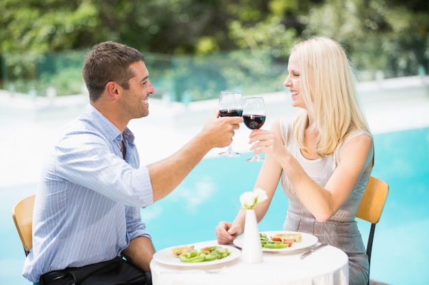 Pareja sonriente con vino tinto