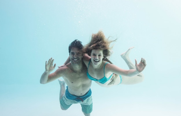 Pareja sonriente bajo vítores de agua