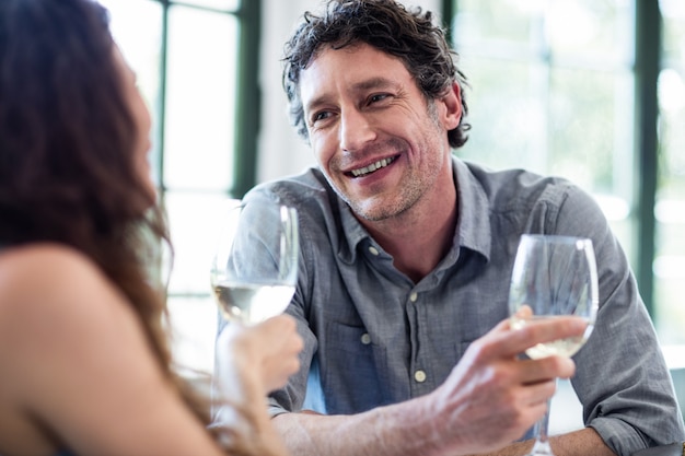 Pareja sosteniendo una copa de vino e interactuando