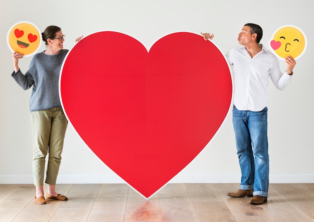 Foto pareja sosteniendo corazón rojo maqueta